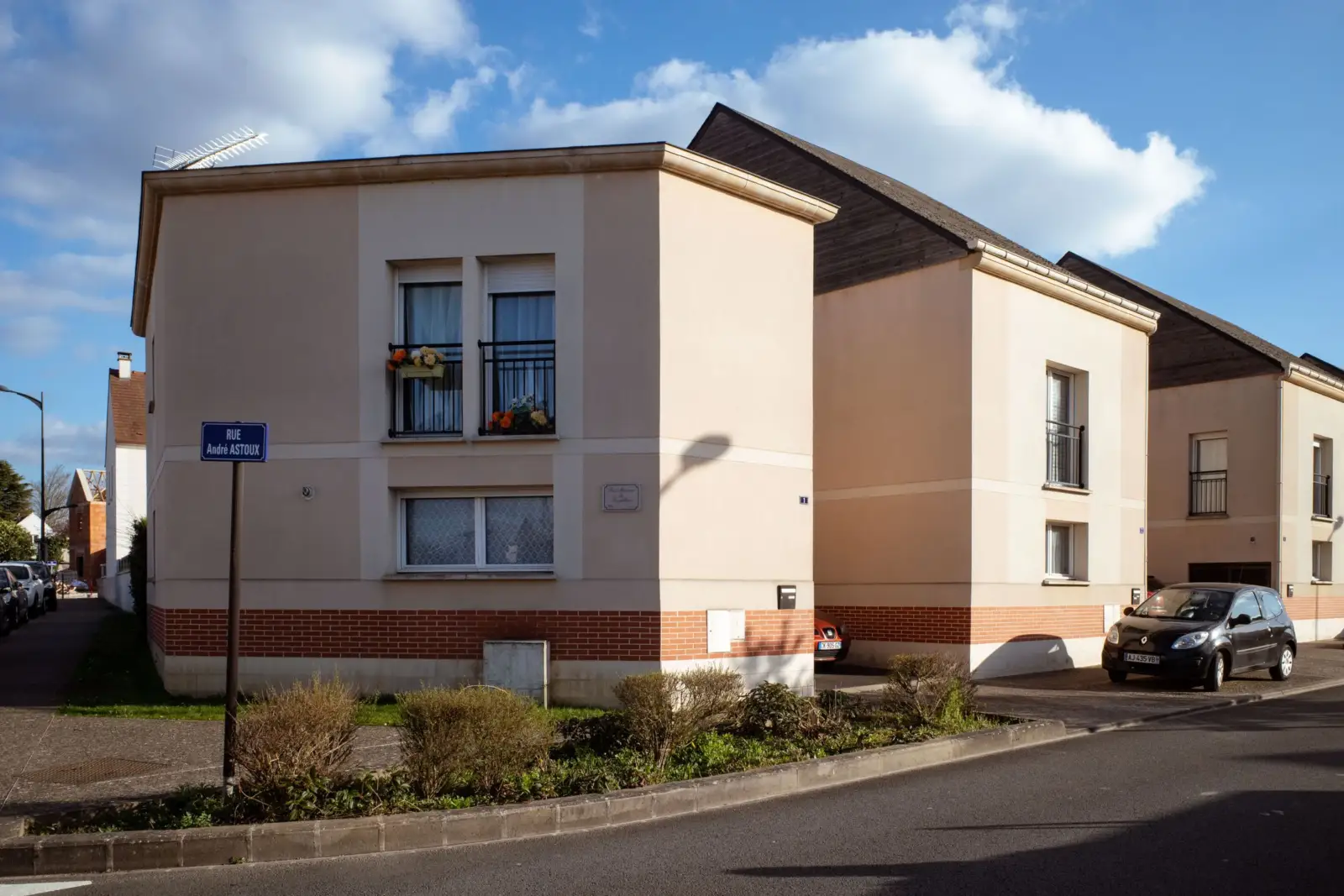 Petits immeubles d'habitation récents au bord d'une rue sous un ciel bleu, à Compiègne