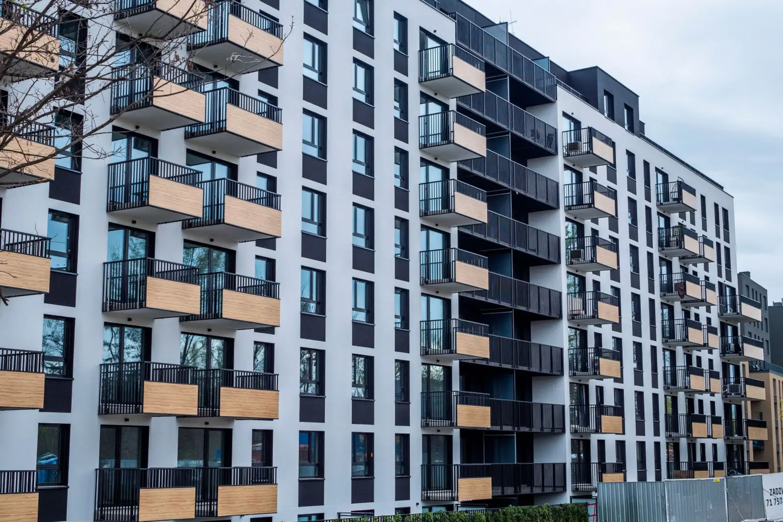 Façade d'un immeuble d'habitation récent avec balcons, sous un ciel bleu